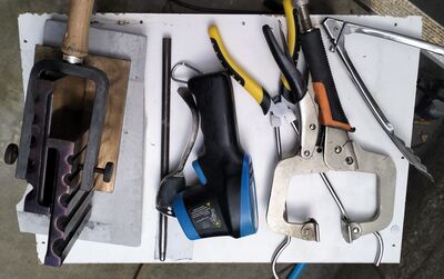 Tooling laid out for a casting session: mould handling, cleanup tools, safety gear, and the small practical items that make the work repeatable